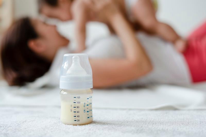 Biberon, mamma e neonato.